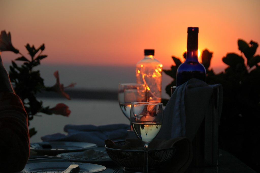 repas d'été accompagné de verres de vins et d'un coucher de soleil 